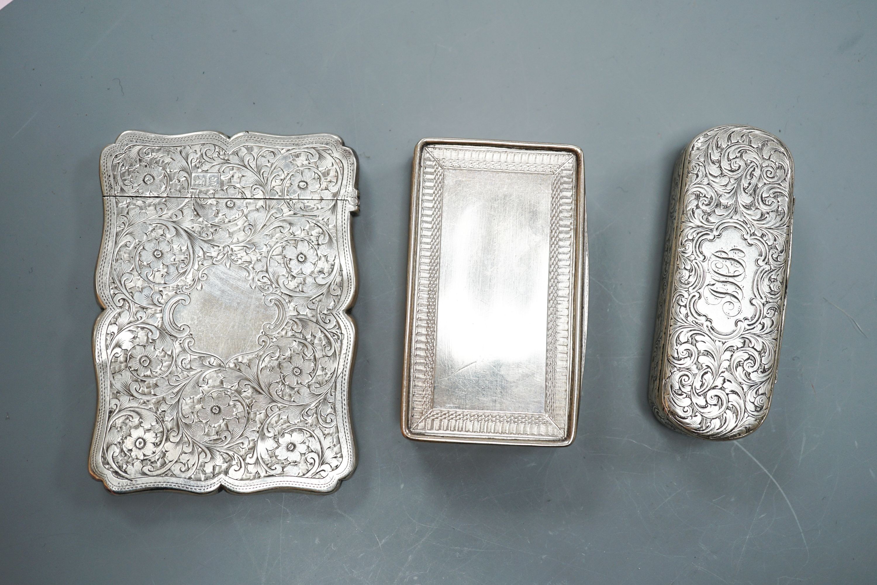 Two English silver snuff boxes, rectangular Birmingham, 1827, 81mm and Edward Smith oval, Birmingham, 1851 together with an Edwardian silver card case, Goldsmiths & Silversmiths, London, 1902.